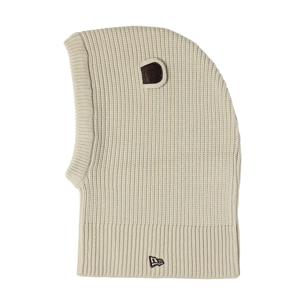 Child New Era Bear Light Beige Balaclava Hat, side view showing the ribbed knit texture in light beige, with a distinctive bear-shaped ear detail on top and the New Era flag logo embroidered in black on the lower edge.