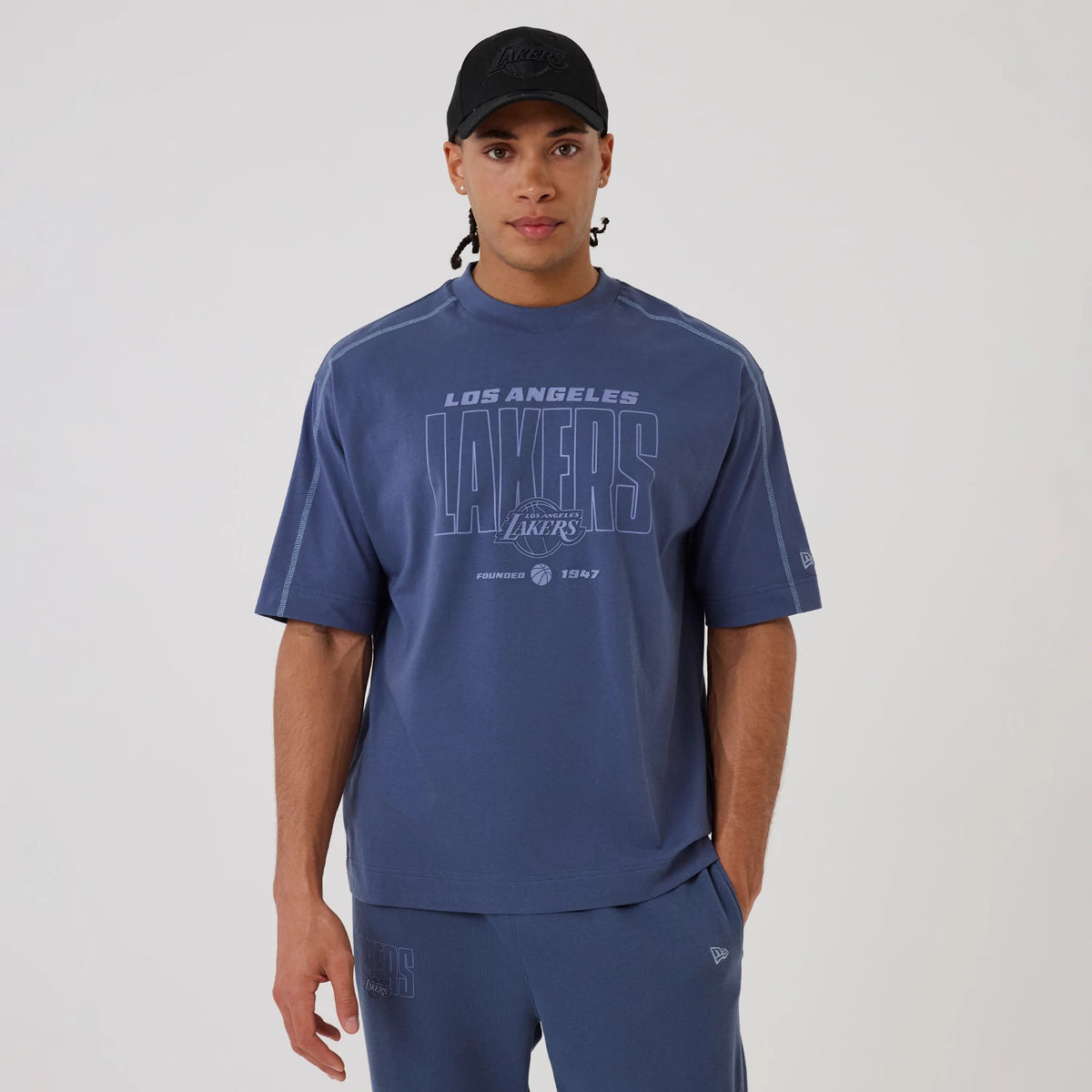 The model is wearing this NBA Graphic LA Lakers Boxy T-Shirt in dark blue. 1