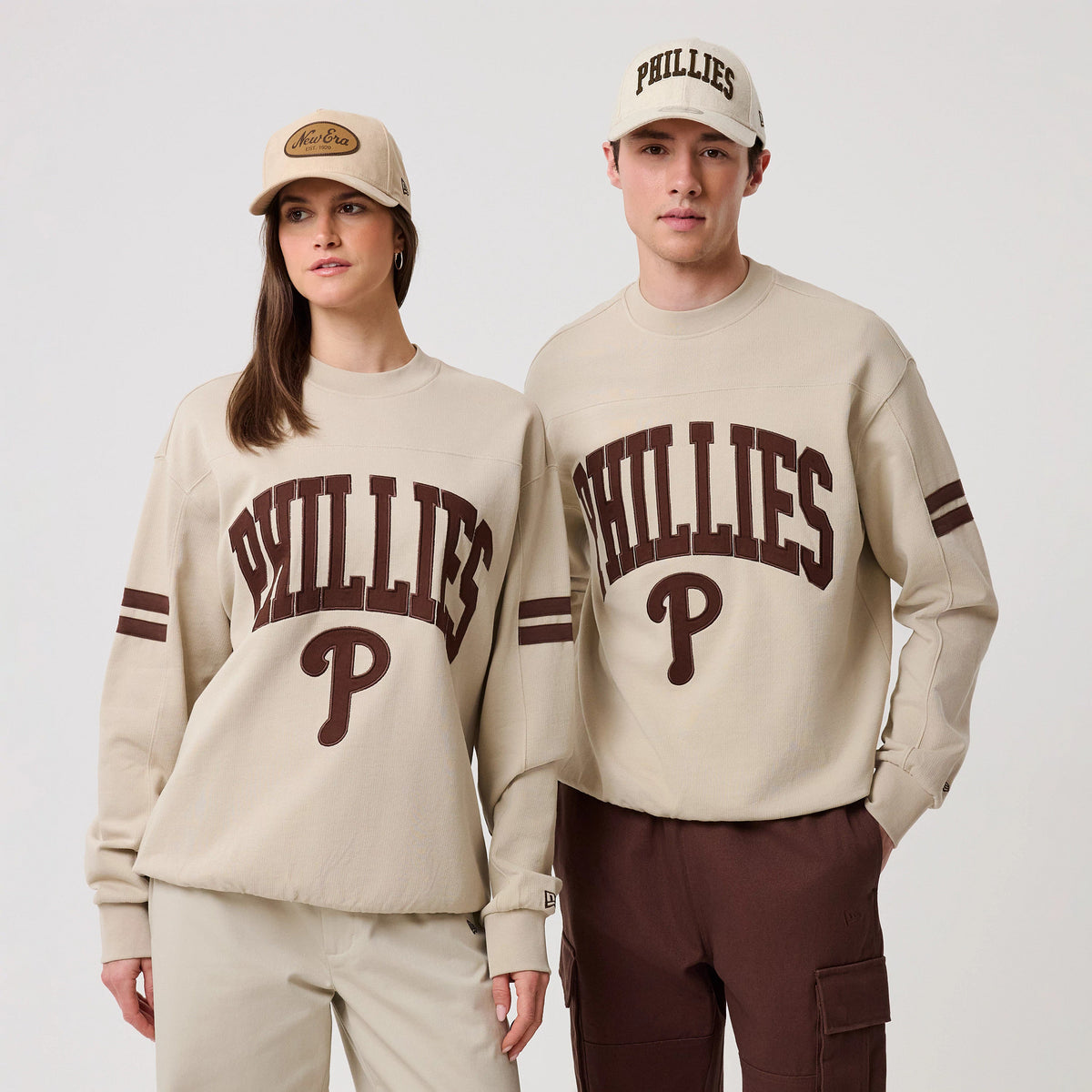 The model is wearing this MLB Arch Graphic Philadelphia Phillies Crew Neck Sweater in light beige. 1