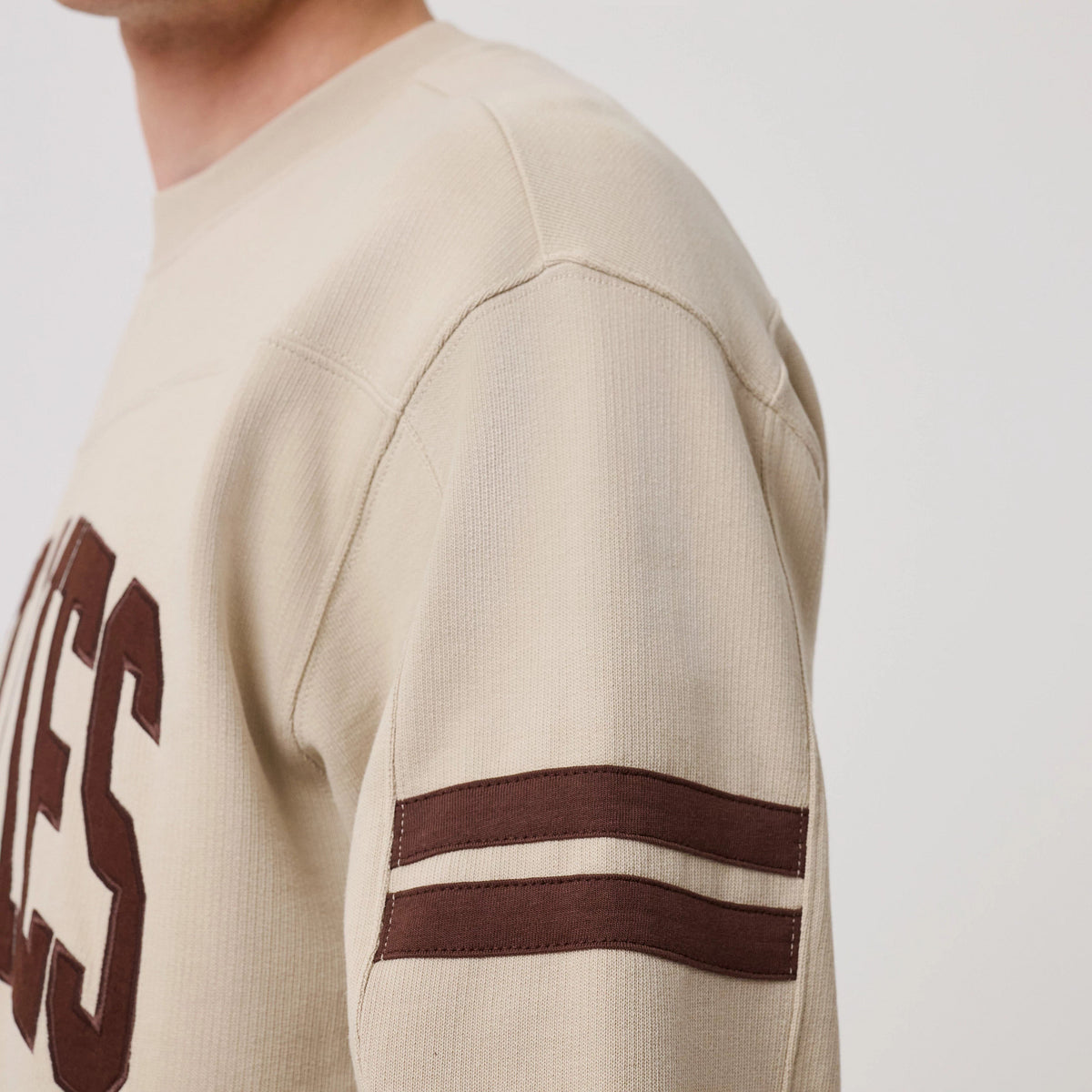 The model is wearing this MLB Arch Graphic Philadelphia Phillies Crew Neck Sweater in light beige. 8