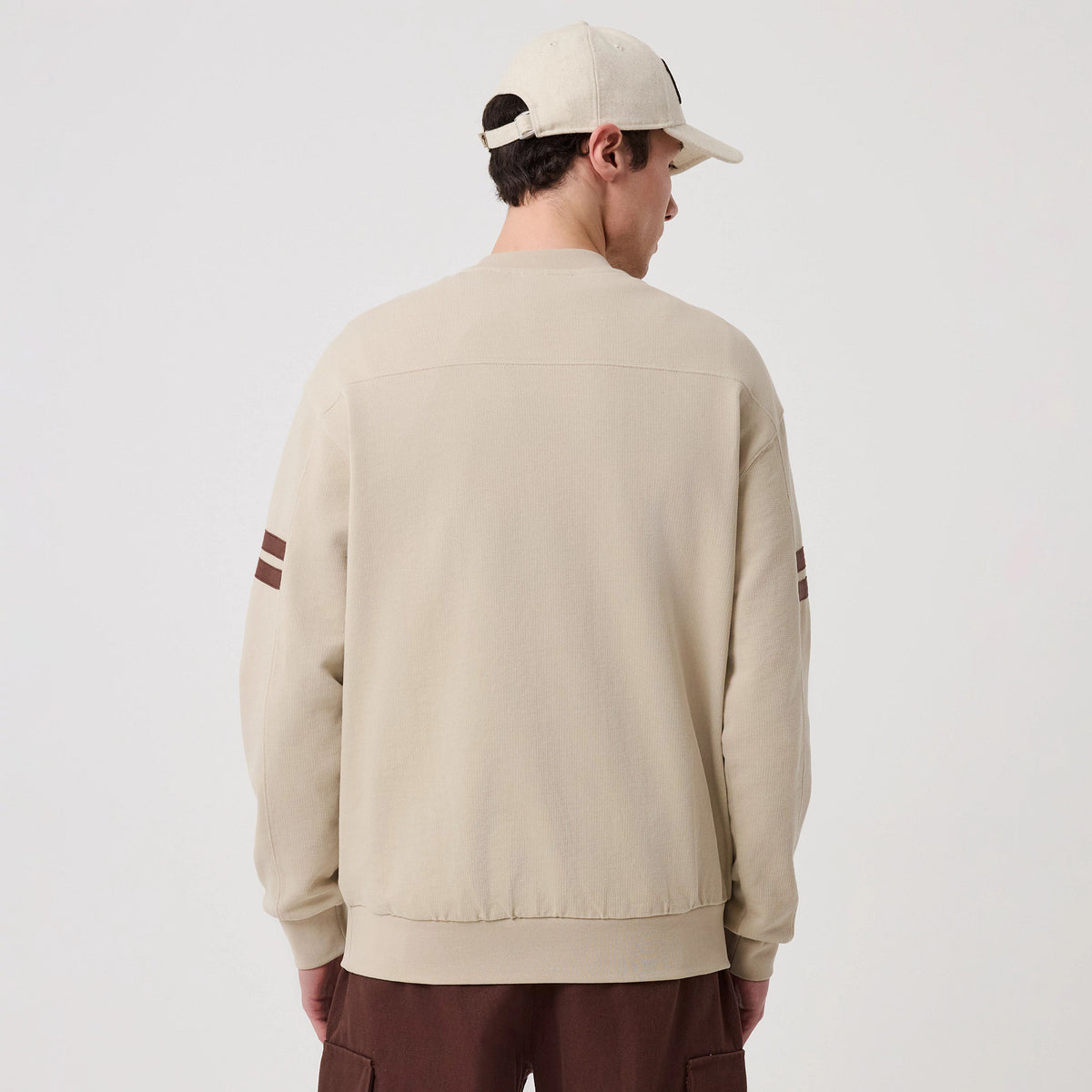 The model is wearing this MLB Arch Graphic Philadelphia Phillies Crew Neck Sweater in light beige. 2