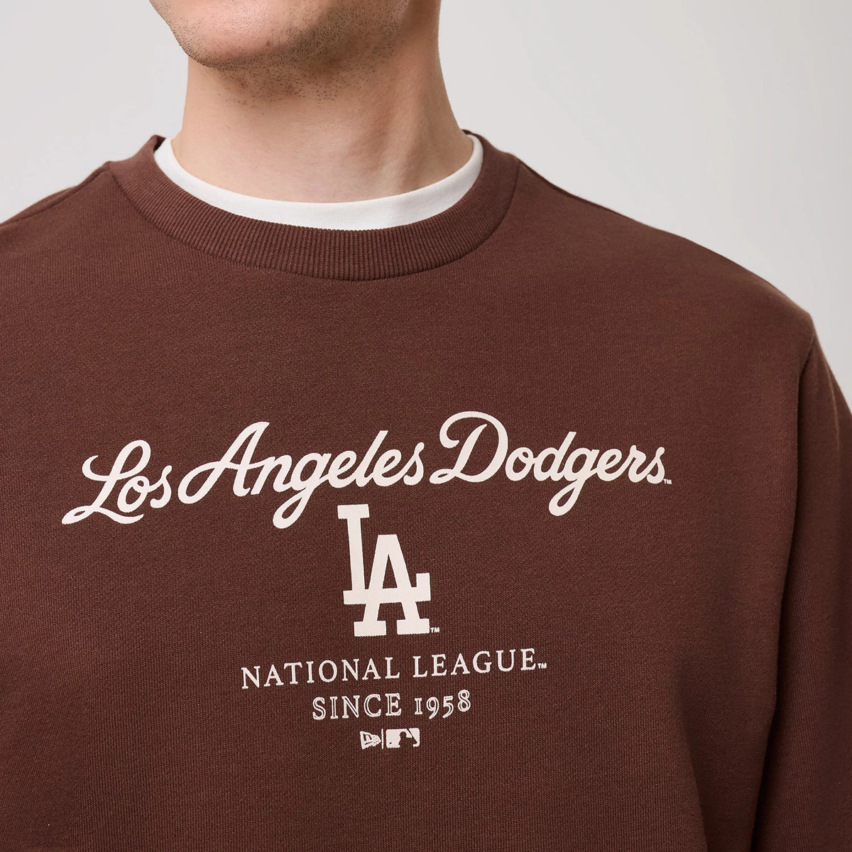 The model is wearing this MLB Linear LA Dodgers Crew Neck Sweater in brown. 5
