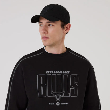 New Era Chicago Bulls NBA Graphic Black Crew Neck Sweater, front view on a model wearing a black cap, featuring grey Bulls lettering across the chest with the team's bull logo and Est. 1966 printed below.