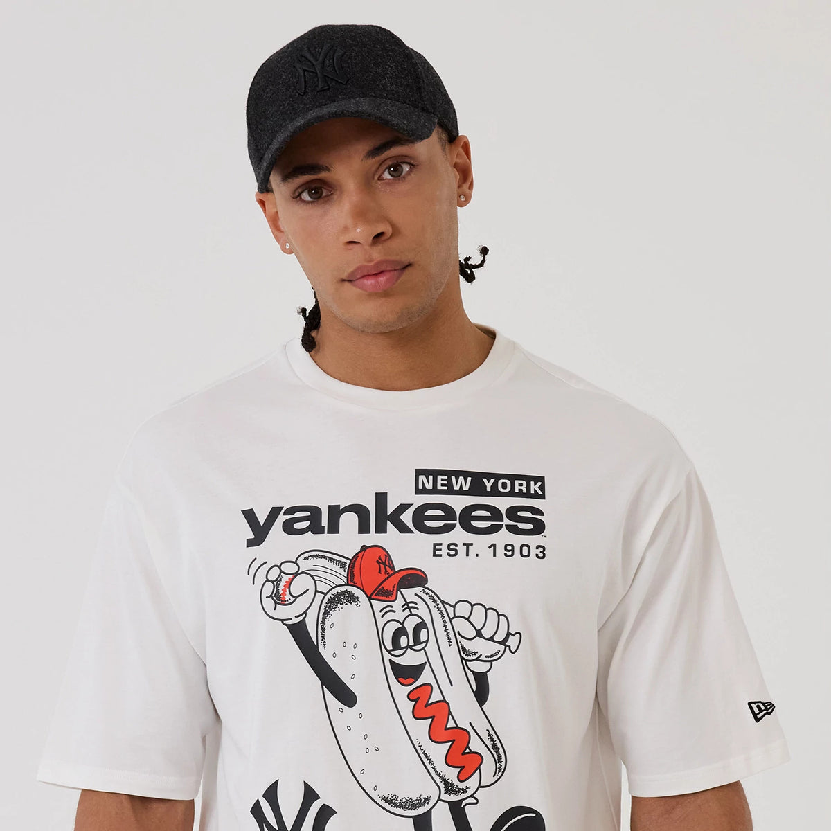 The model is wearing this MLB Hotdog Graphic New York Yankees Oversized T-Shirt in white. 5