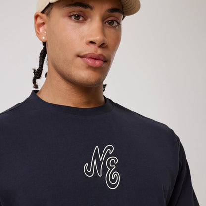 The model is wearing this New Era Crest Graphic Oversized T-Shirt in navy. 5
