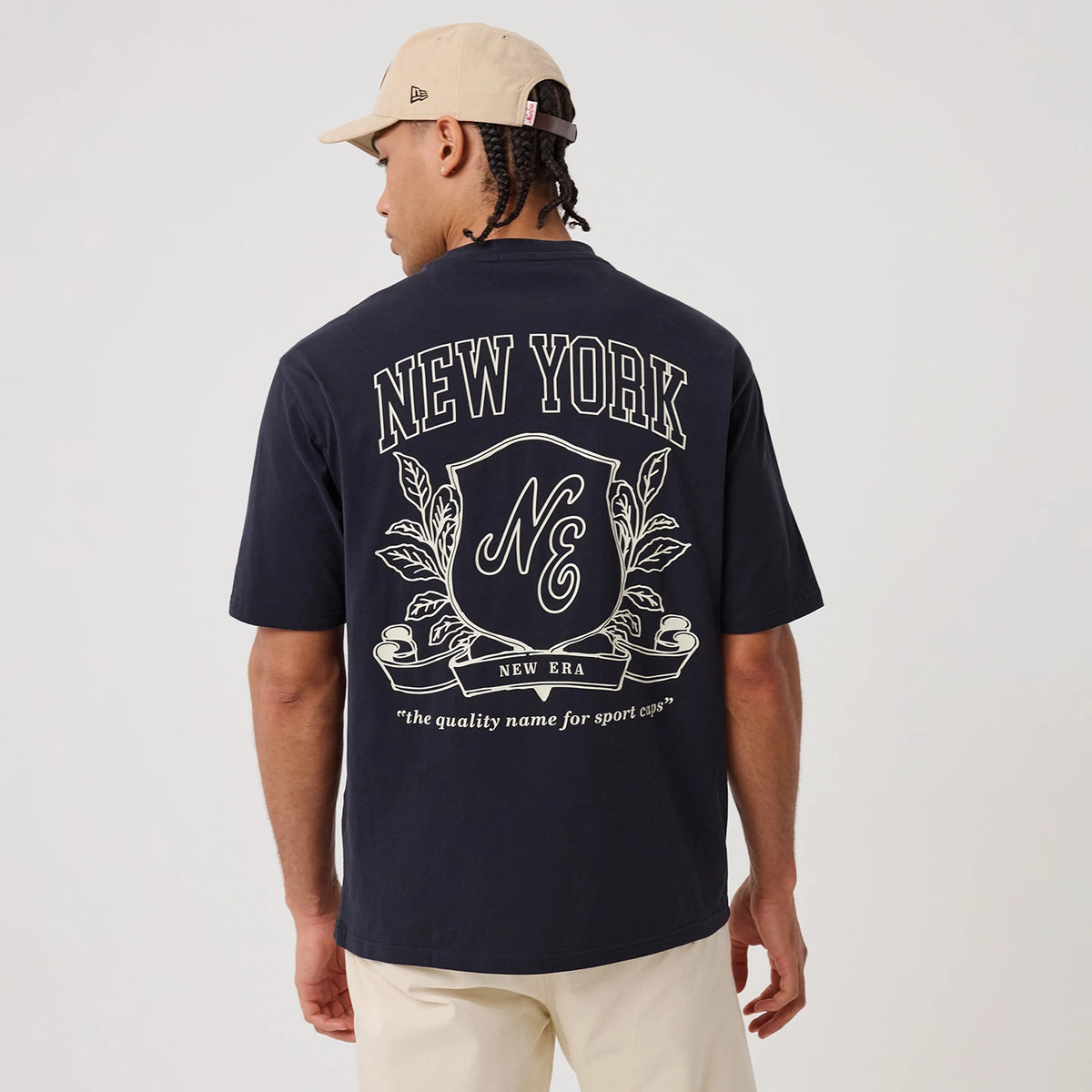 The model is wearing this New Era Crest Graphic Oversized T-Shirt in navy. 2