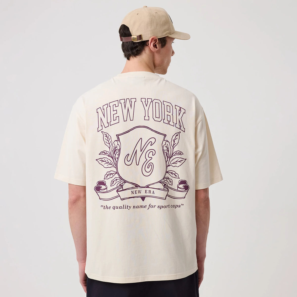 The model is wearing this New Era Crest Graphic Oversized T-Shirt in open white. 2