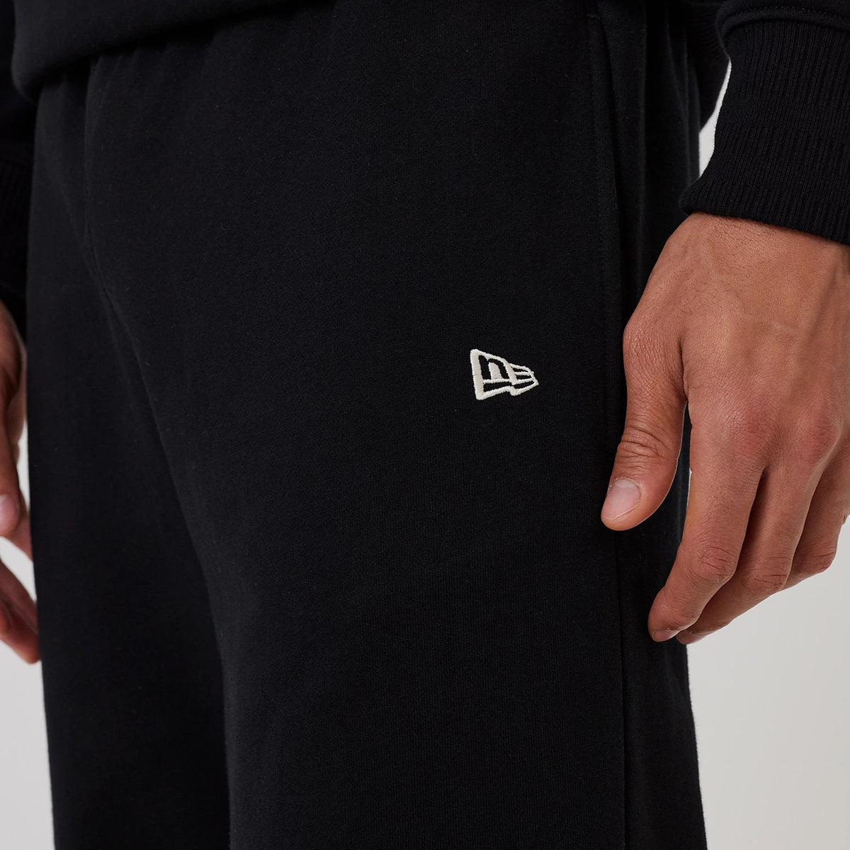 New Era New York Yankees MLB Black Wide Leg Joggers, side view on a model with the white New Era flag logo embroidered near the left pocket, showcasing the relaxed fit and ribbed waistband of the black joggers.