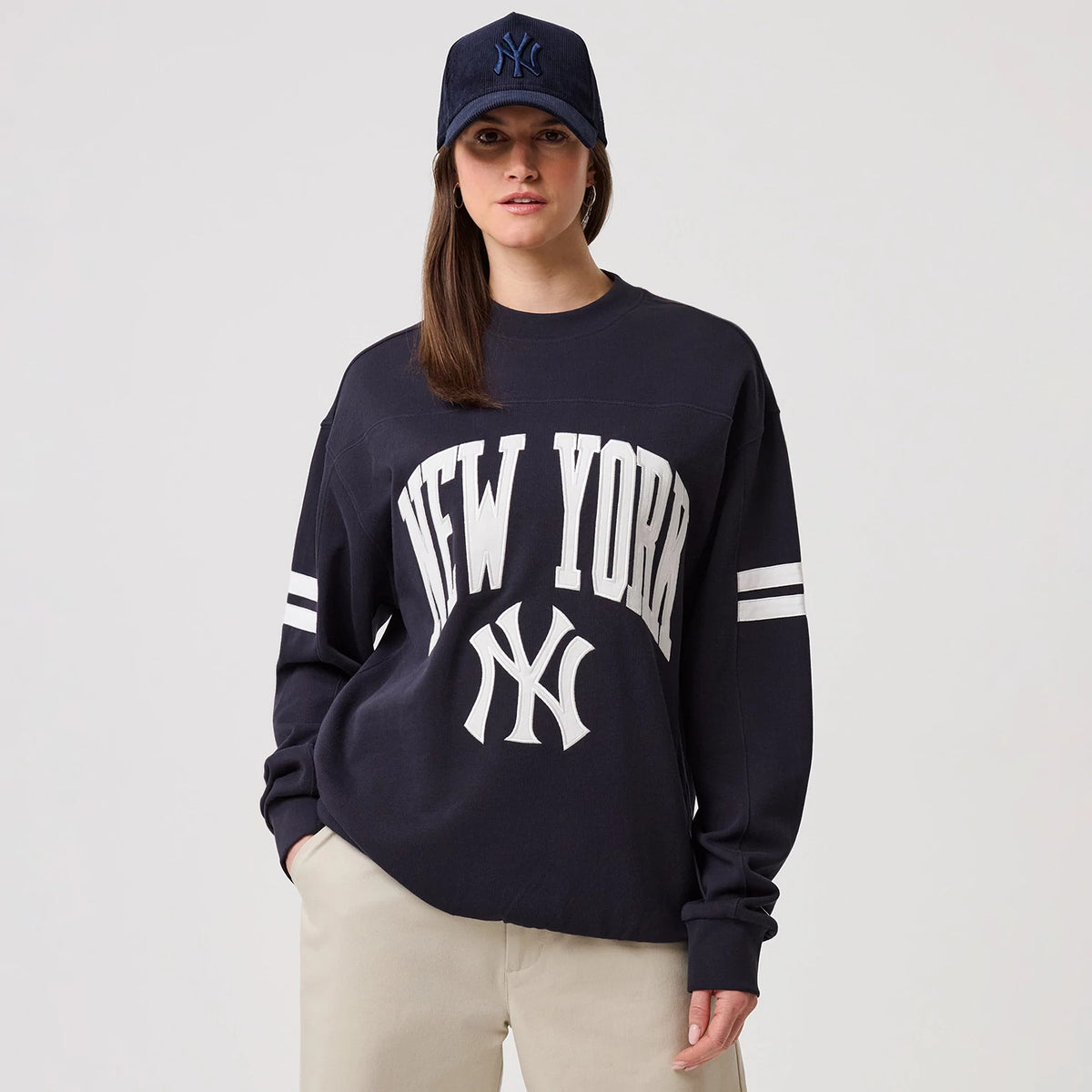 The model is wearing this MLB Arch Graphic New York Yankees Crew Neck Sweater in navy. 4