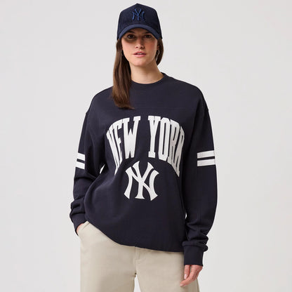 The model is wearing this MLB Arch Graphic New York Yankees Crew Neck Sweater in navy. 4
