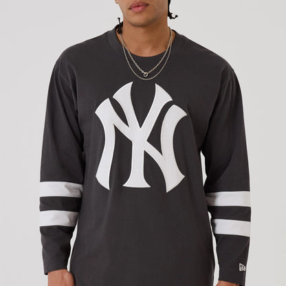 The model is wearing this MLB League Essential New York Yankees Oversized Jersey in charcoal. 3