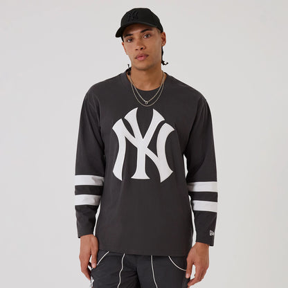 The model is wearing this MLB League Essential New York Yankees Oversized Jersey in charcoal. 1