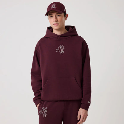 The model is wearing this New Era Crest Graphic Pullover Hoodie in dark purple. 3
