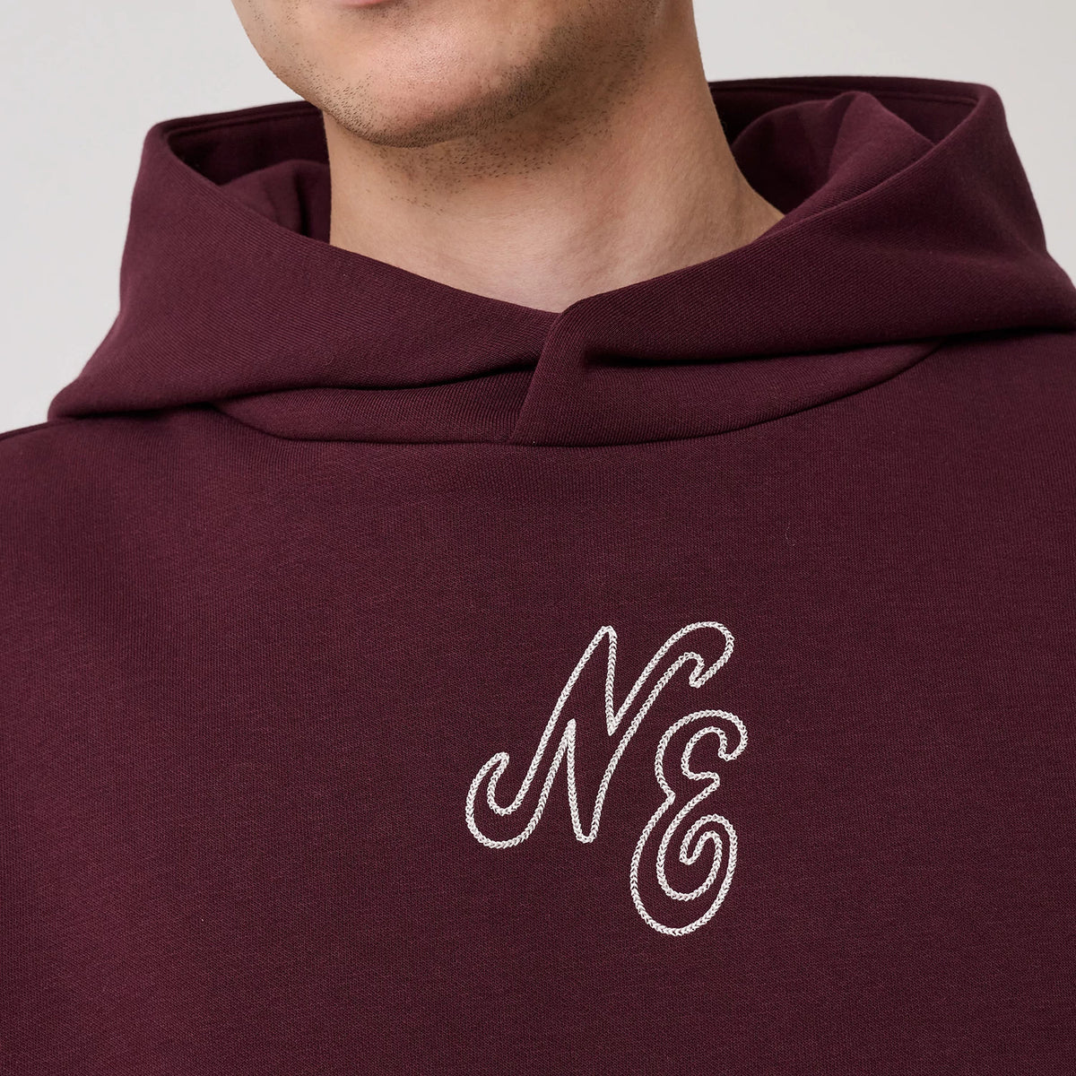 The model is wearing this New Era Crest Graphic Pullover Hoodie in dark purple. 5