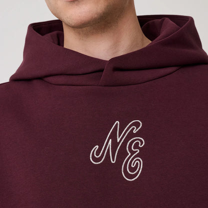 The model is wearing this New Era Crest Graphic Pullover Hoodie in dark purple. 5