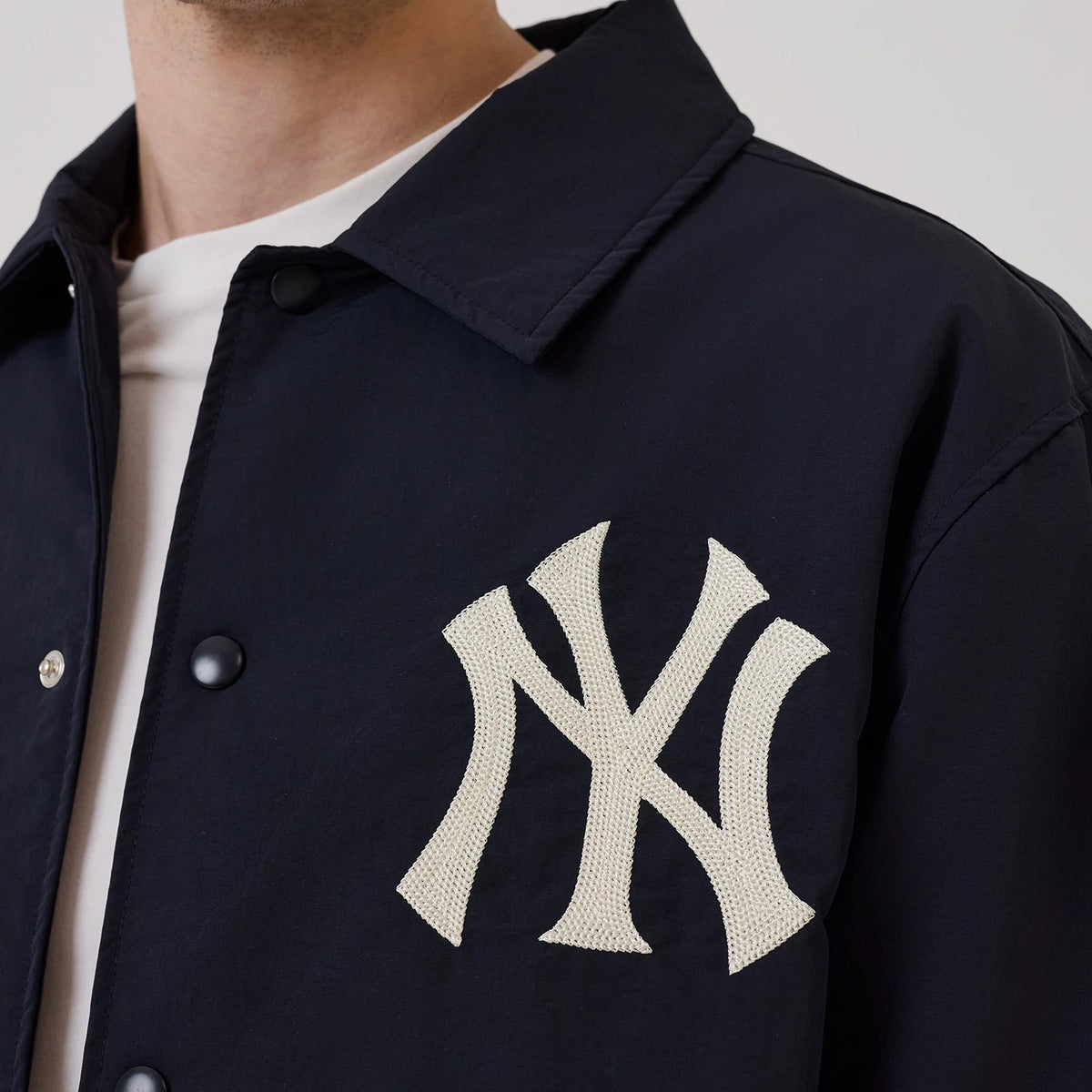 The model is wearing this MLB New York Yankees Coach Jacket in navy. 5