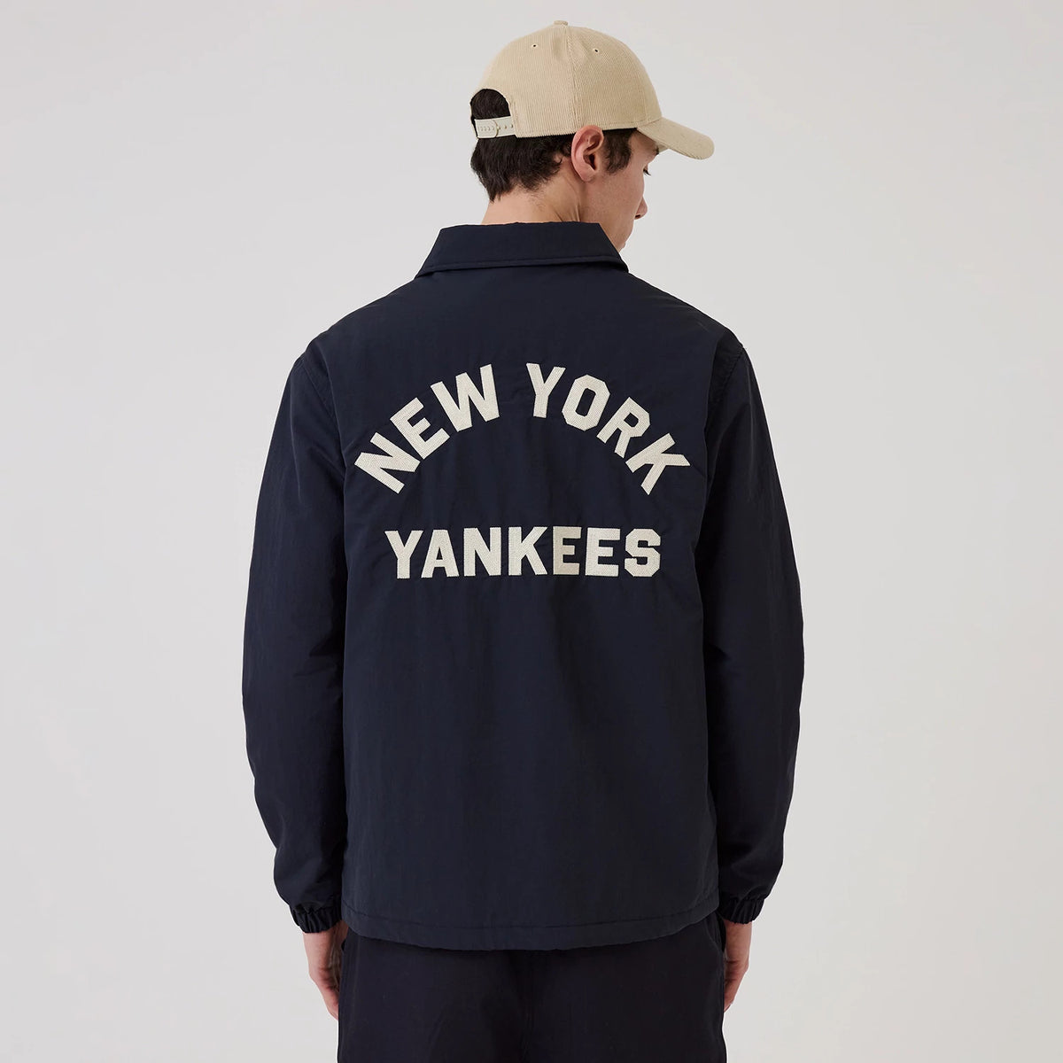 The model is wearing this MLB New York Yankees Coach Jacket in navy. 2