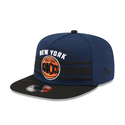New York Knicks NBA Tip Off 2026 Dark Blue New Era 9FIFTY A-Frame Snapback Adjustable Cap, front view showing the white embroidered New York lettering above the orange Knicks logo on the dark blue crown, with a black flat visor.