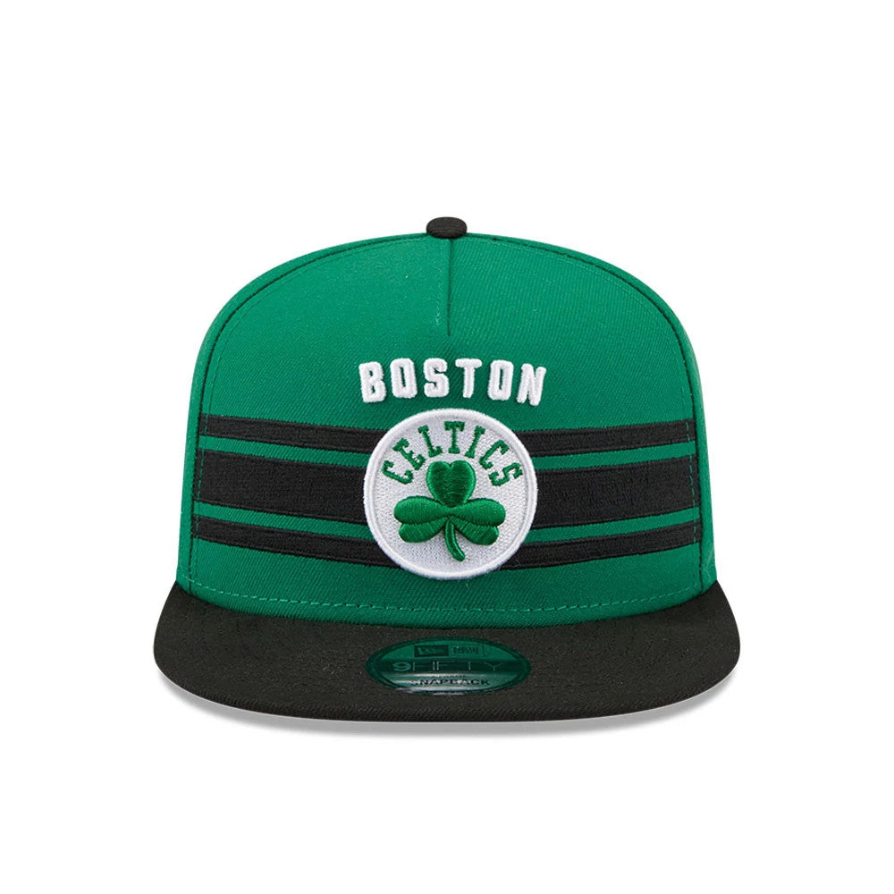 Boston Celtics NBA Tip Off 2026 Green New Era 9FIFTY A-Frame Snapback Adjustable Cap, front view showing a raised white Boston embroidery and a central Celtics logo with a green shamrock, black stripes across the green crown.