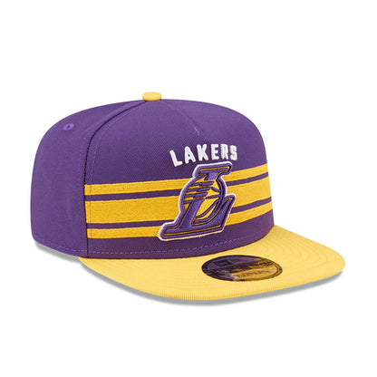 LA Lakers NBA Tip Off 2026 Purple New Era 9FIFTY A-Frame Snapback Adjustable Cap, front view showing the raised embroidered Lakers wordmark and L logo on the front panel, two yellow horizontal stripes, and a purple crown with a gold visor.