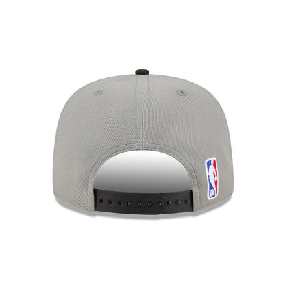 Brooklyn Nets NBA Tip Off 2026 Dark Grey New Era 9FIFTY A-Frame Snapback Adjustable Cap, rear view showing an embroidered NBA logo on the left side of the light grey structured crown, with a black adjustable snapback closure and two grey eyelets.