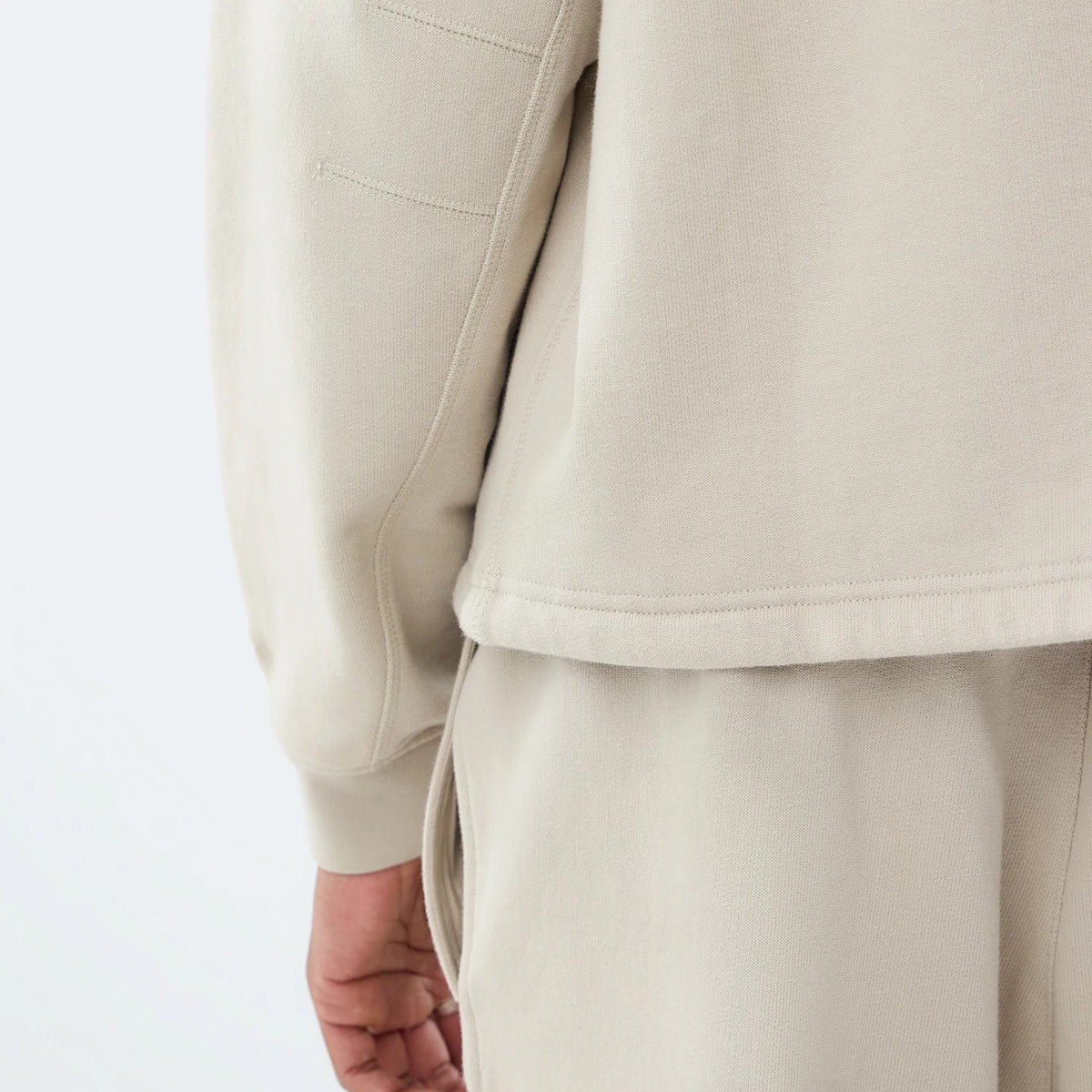 The model is wearing this New Era Open Hem Oversized Crew Neck Sweater in light beige. 5