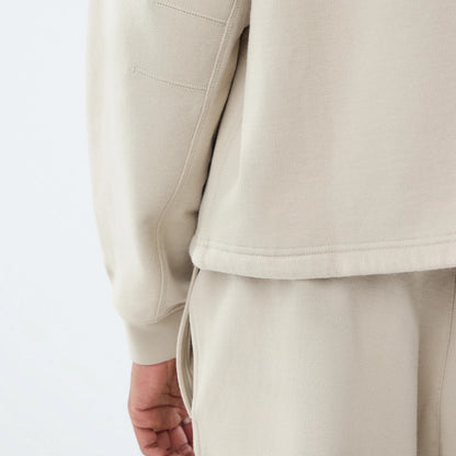The model is wearing this New Era Open Hem Oversized Crew Neck Sweater in light beige. 5