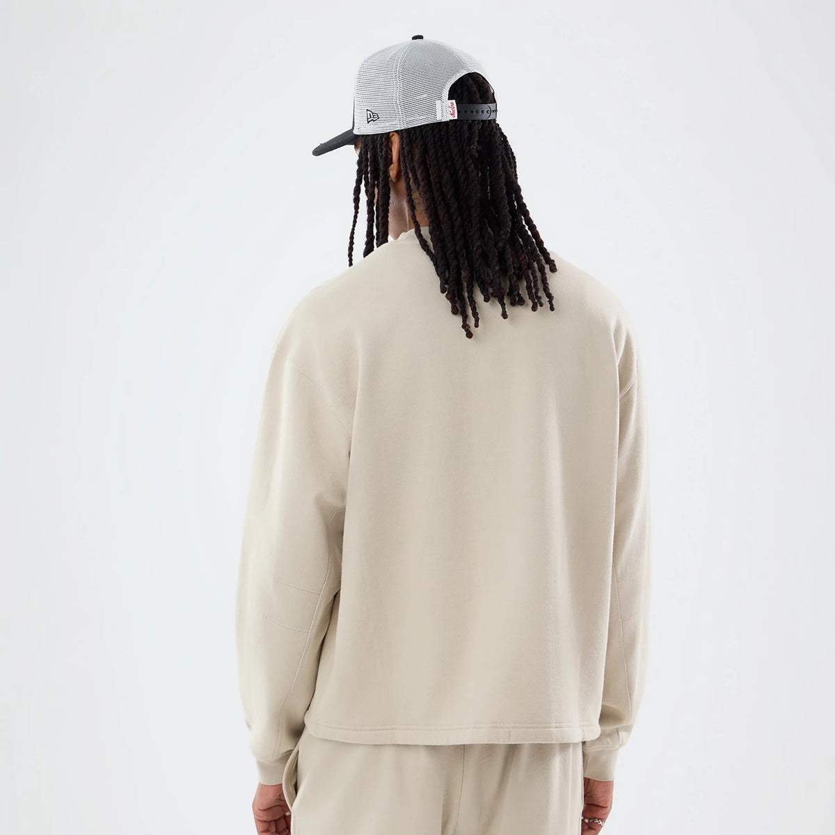 The model is wearing this New Era Open Hem Oversized Crew Neck Sweater in light beige. 2