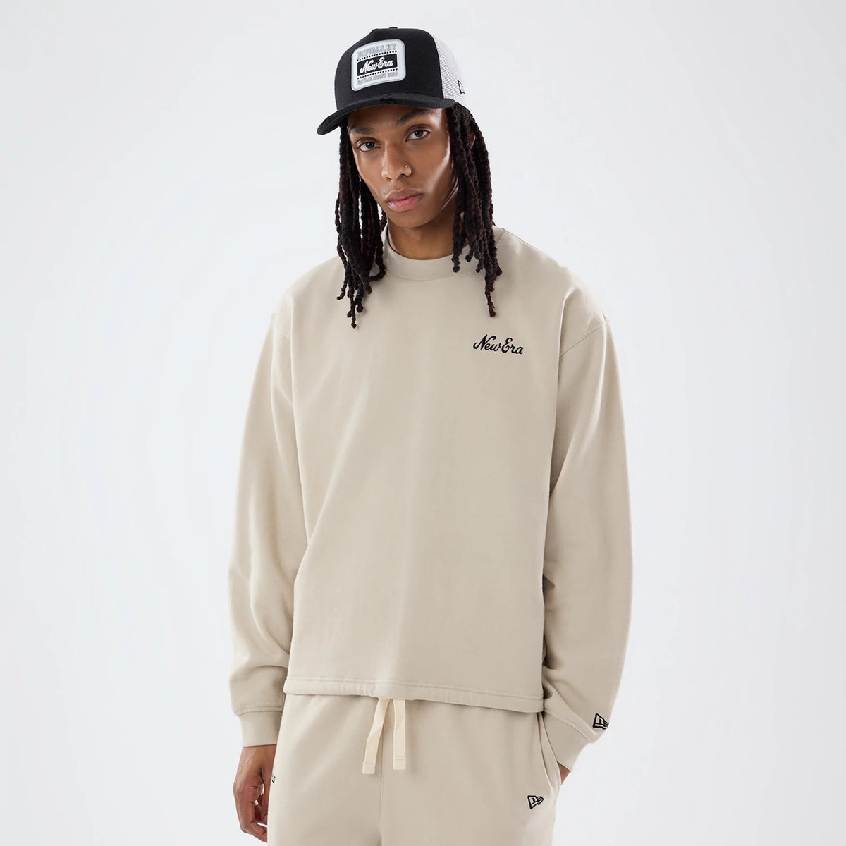 The model is wearing this New Era Open Hem Oversized Crew Neck Sweater in light beige. 1