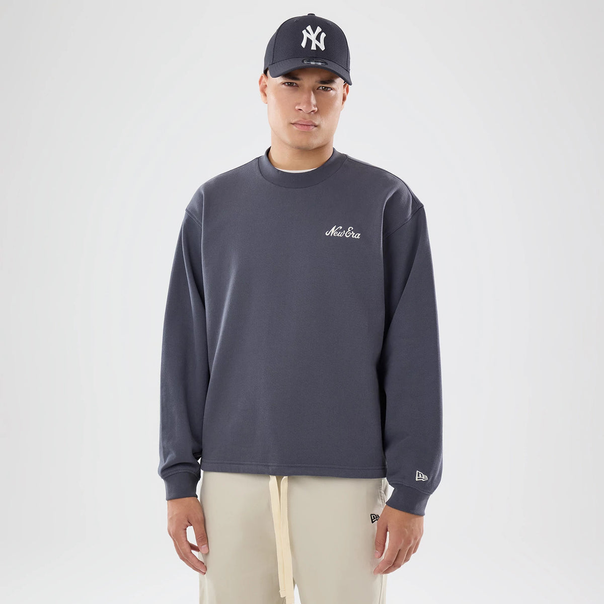 The model is wearing this New Era Open Hem Oversized Crew Neck Sweater in dark grey. 1