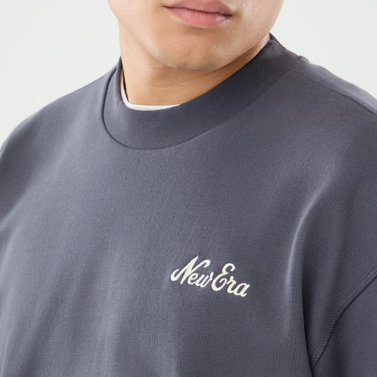 The model is wearing this New Era Open Hem Oversized Crew Neck Sweater in dark grey. 4