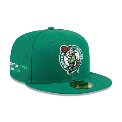 Boston Celtics NBA X J-FROST Green New Era 59FIFTY Fitted Cap, three-quarter view showing the raised embroidered Celtics logo on the front panel, a flat visor with a gold 59FIFTY size sticker, and white Boston Don’t Love You text on the side.