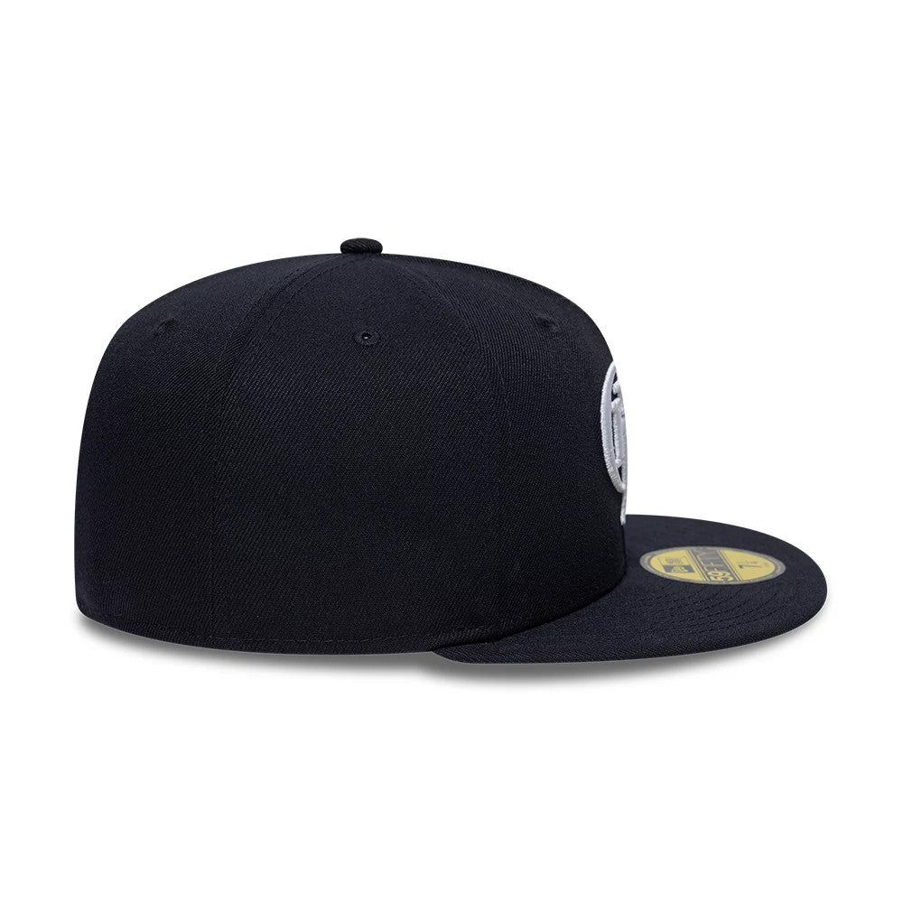 Gettomasa X New Era Navy 59FIFTY Fitted Cap, side view showing the structured navy crown with a grey embroidered logo on the front panel, a flat navy visor, and a gold 59FIFTY size sticker on the top of the visor.