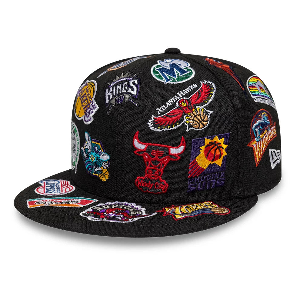 NBA All Over Hardwood Classic All Over Black New Era 59FIFTY Fitted Cap, three-quarter view showing multiple team logos including a prominent red Bulls logo, richly embroidered across the black crown and visor, with the New Era flag logo on the left.