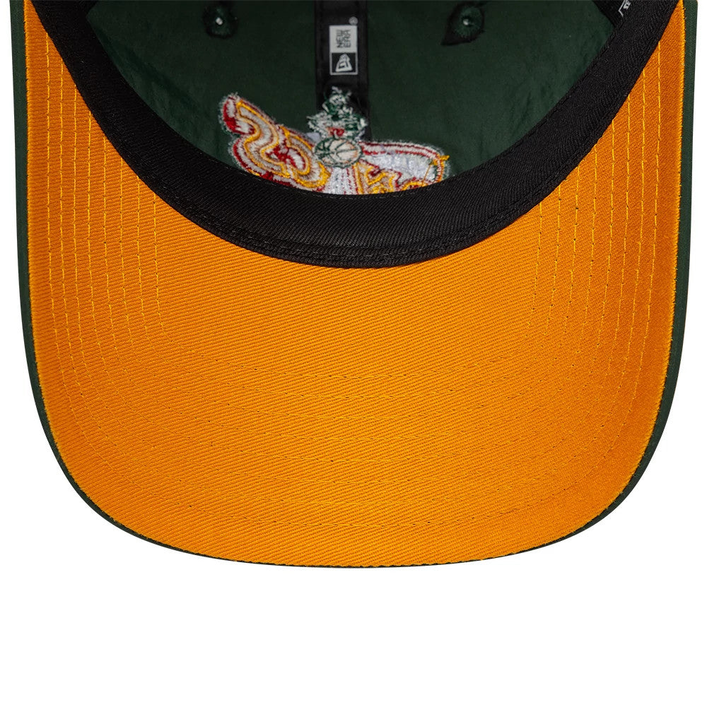 Supersonics NBA Hardwood Classic Nylon Green New Era 9TWENTY Adjustable Cap, inside view showing a gold undervisor with contrasting black trim, an embroidered patch on the inner side of the front panel, and black taping along the seams.