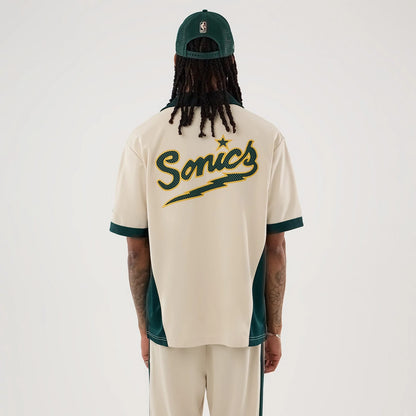 The model is wearing this NBA Hardwood Classic Revere Seattle Supersonics Short Sleeve Shirt in light beige. 2