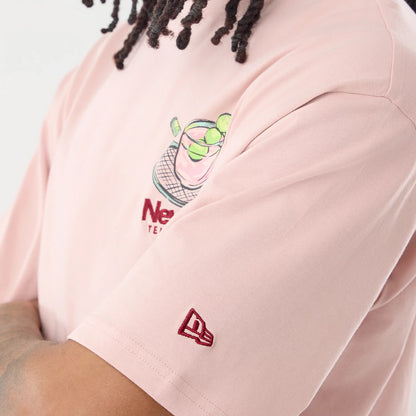 The model is wearing this New Era Tennis Graphic Oversized T-Shirt in pastel pink. 7