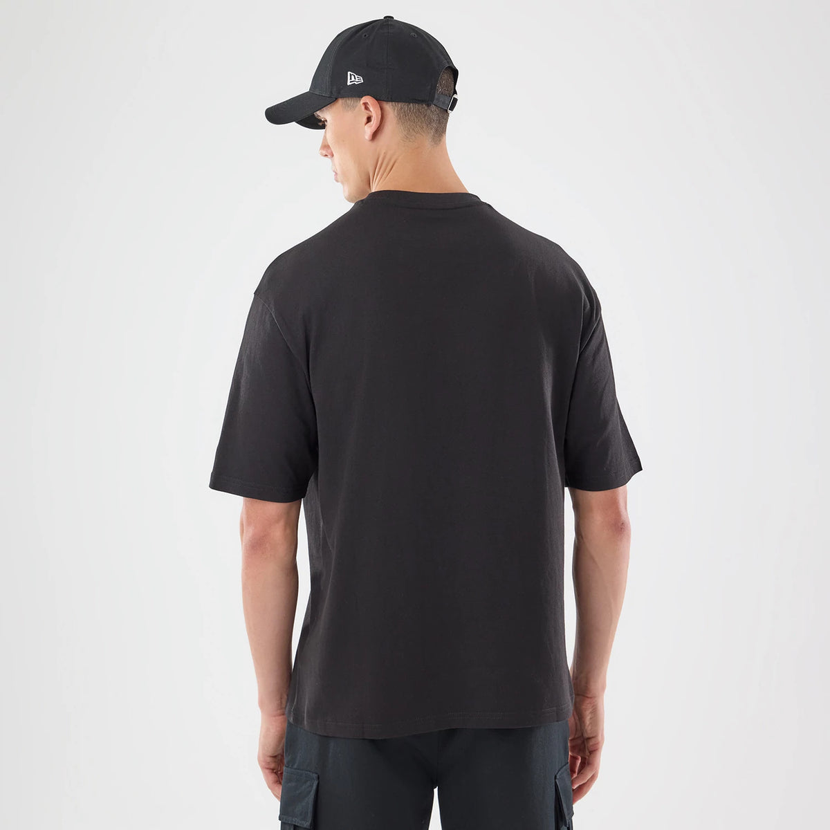 The model is wearing this New Era Skull Graphic Oversized T-Shirt in black. 2