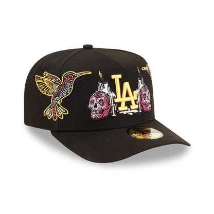 LA Dodgers MLB Day Of The Dead Black New Era 59FIFTY A-Frame Fitted Cap, three-quarter view showing multicoloured embroidered skulls and hummingbird on front panels, with prominent gold LA logo in the centre.