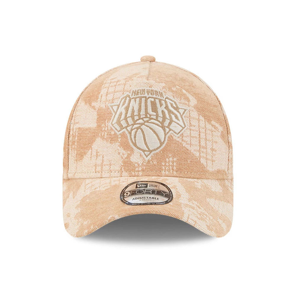 New York Knicks NBA Fall Story Beige New Era 9FORTY A-Frame Adjustable Cap, front view showing the white embroidered Knicks logo on the centre of the structured beige crown with a beige camo pattern and a 9FORTY size sticker on the curved visor.