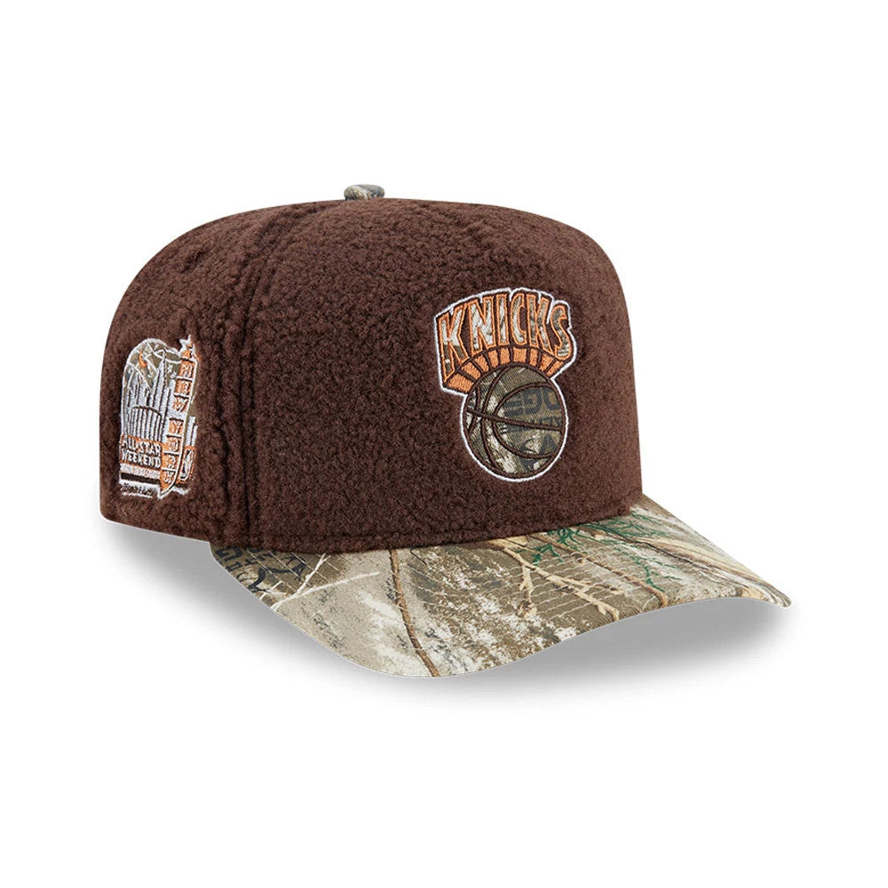 New York Knicks NBA Hardwood Classic Brown New Era 59FIFTY A-Frame Fitted Cap, three-quarter view showing the embroidered Knicks logo on the front panel, camo pattern on the curved visor, and detailed side patch with basketball theme.