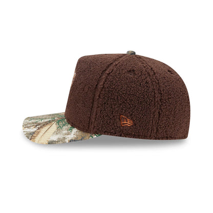 New York Knicks NBA Hardwood Classic Brown New Era 59FIFTY A-Frame Fitted Cap, side view showing the orange embroidered New Era flag logo on a brown textured crown and a multicoloured patterned visor with earthy tones.