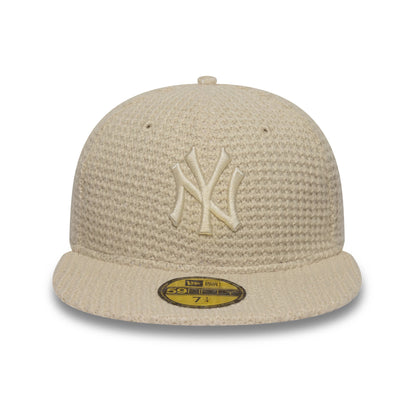 New York Yankees MLB Knitted Light Beige New Era 59FIFTY Fitted Cap, front view showing the raised embroidered NY logo on the structured crown, light beige textured knit fabric, and gold 59FIFTY size sticker on the flat visor.