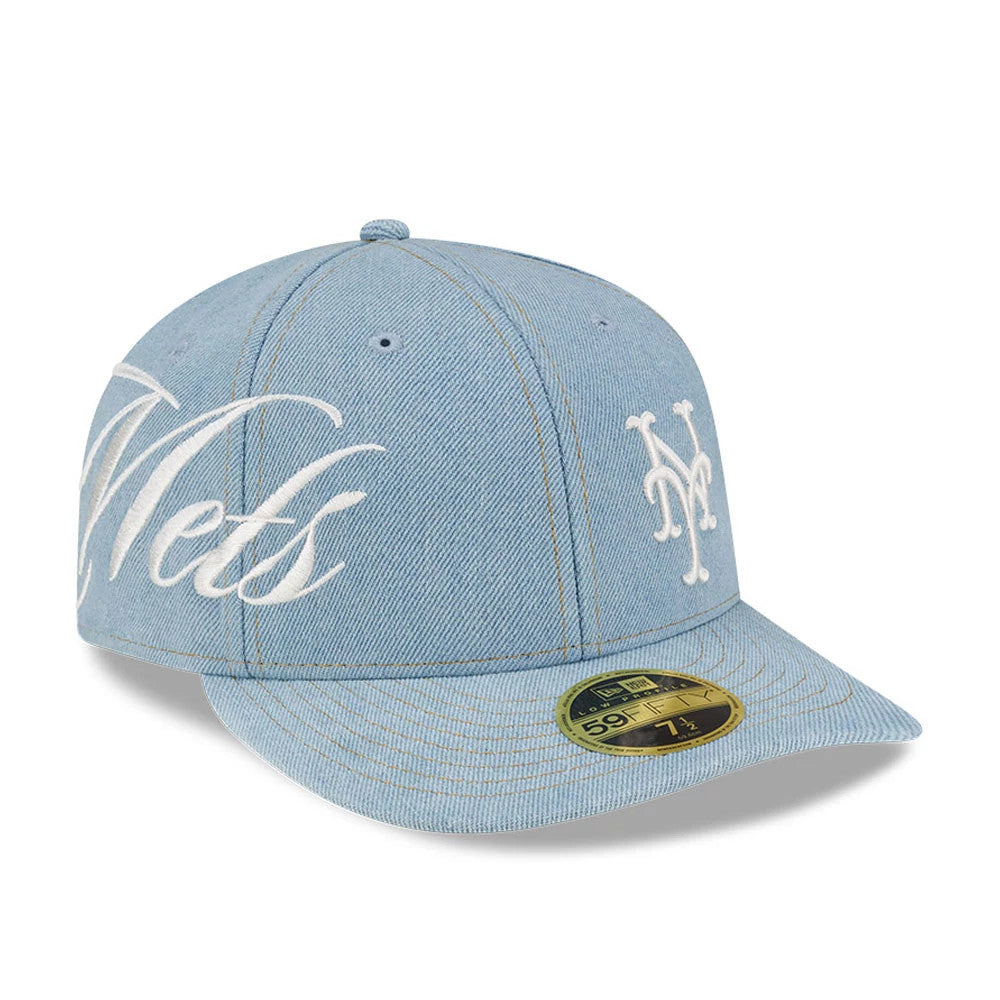 New York Mets MLB Denim Pastel Blue New Era Low Profile 59FIFTY Fitted Cap, three-quarter view showing the large white Mets script embroidered on the side, the team logo on the front panel, and the gold 59FIFTY size sticker on the flat visor.