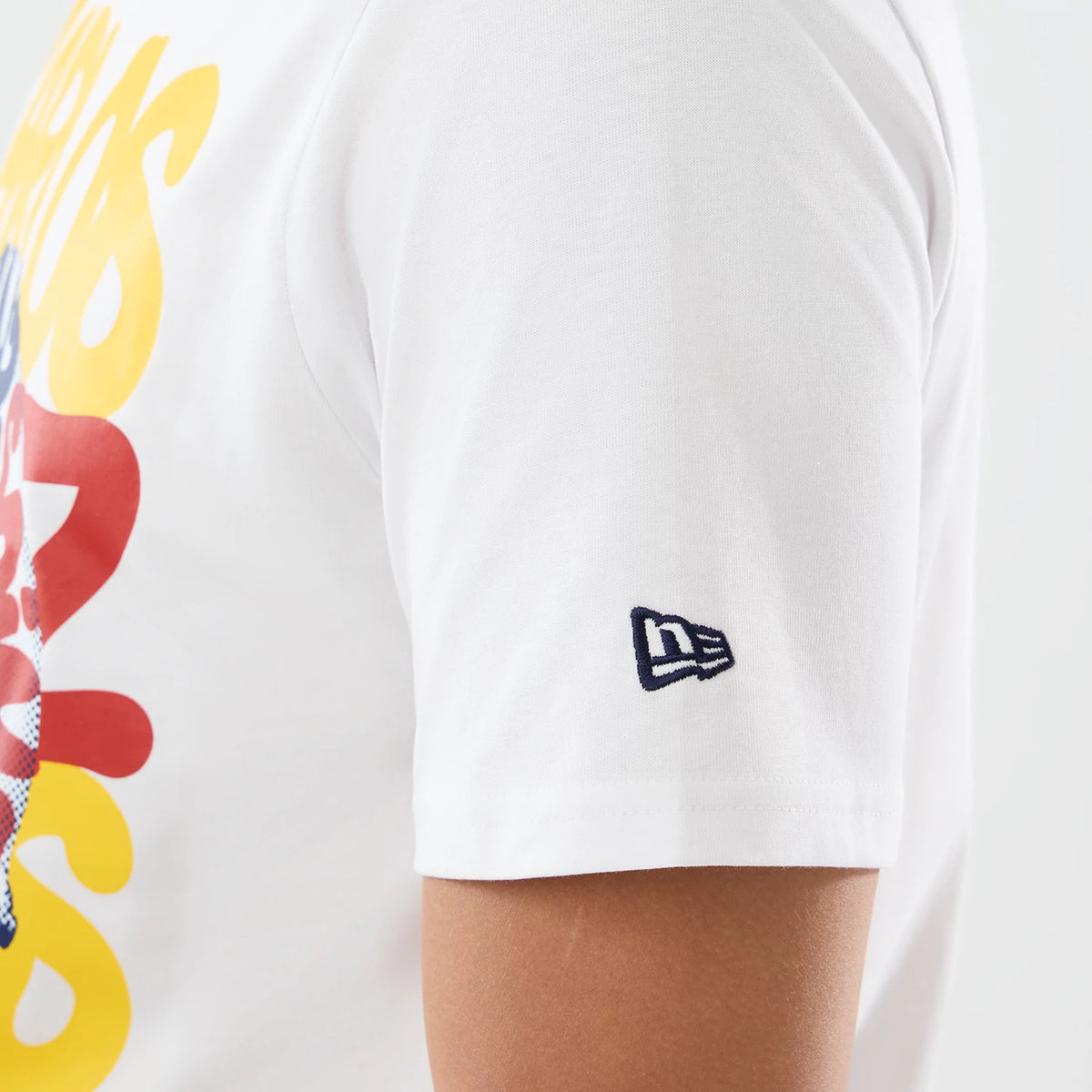 New Era Williams Carlos Sainz Spain Race Special White T-Shirt, side view showcasing a close-up of the right sleeve featuring an embroidered New Era logo, with yellow and red graphics on the front of the garment.