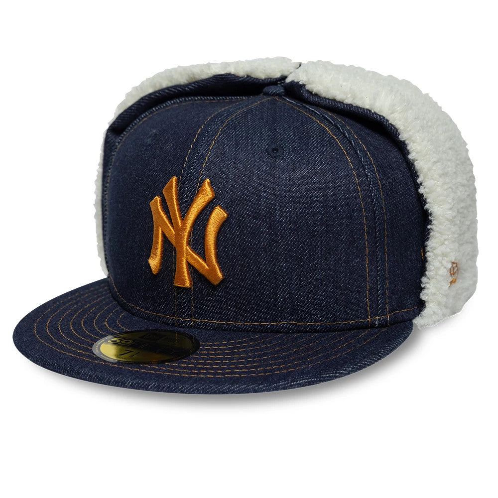 New York Yankees MLB Denim Navy Dogear New Era 59FIFTY Fitted Cap, front view showing a raised gold NY logo embroidered on the denim crown, with white dogear flaps and a 59FIFTY size sticker on the flat navy visor.