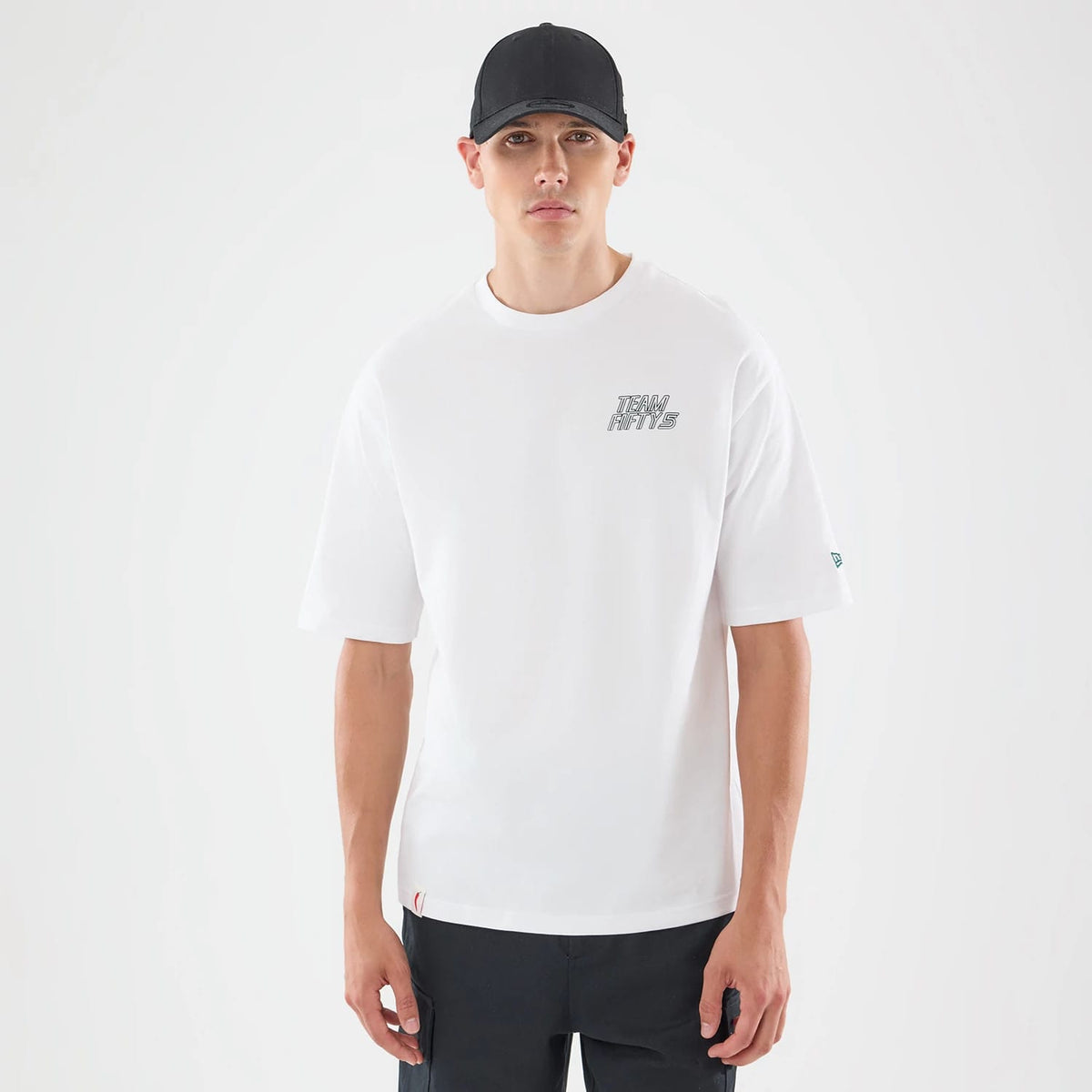 The model is wearing this Carlos Sainz Team Fifty5 Mexico Oversized T-Shirt in white. 1
