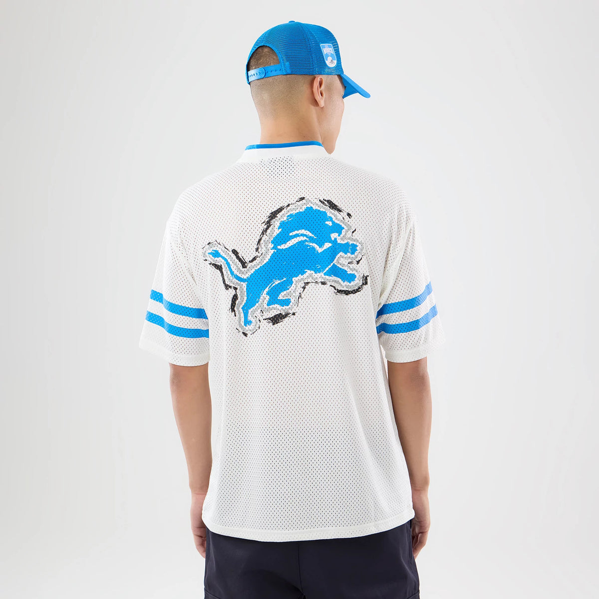 The model is wearing this NFL International Series Games 2026 Graphic Detroit Lions Mesh Jersey in white. 2