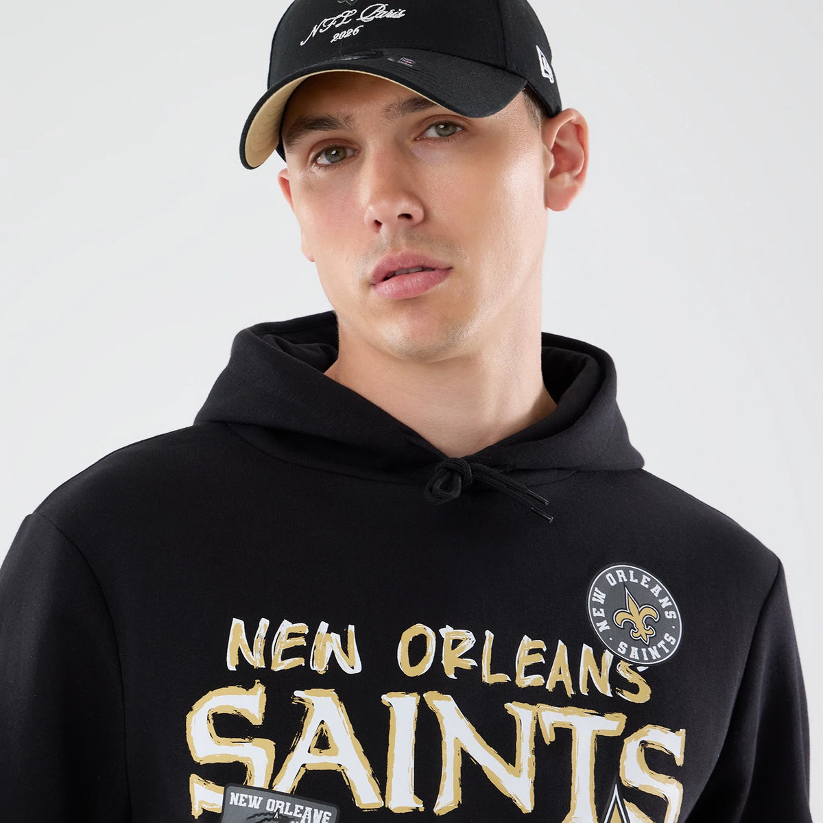 The model is wearing this NFL Patch New Orleans Saints Pullover Hoodie in black. 6