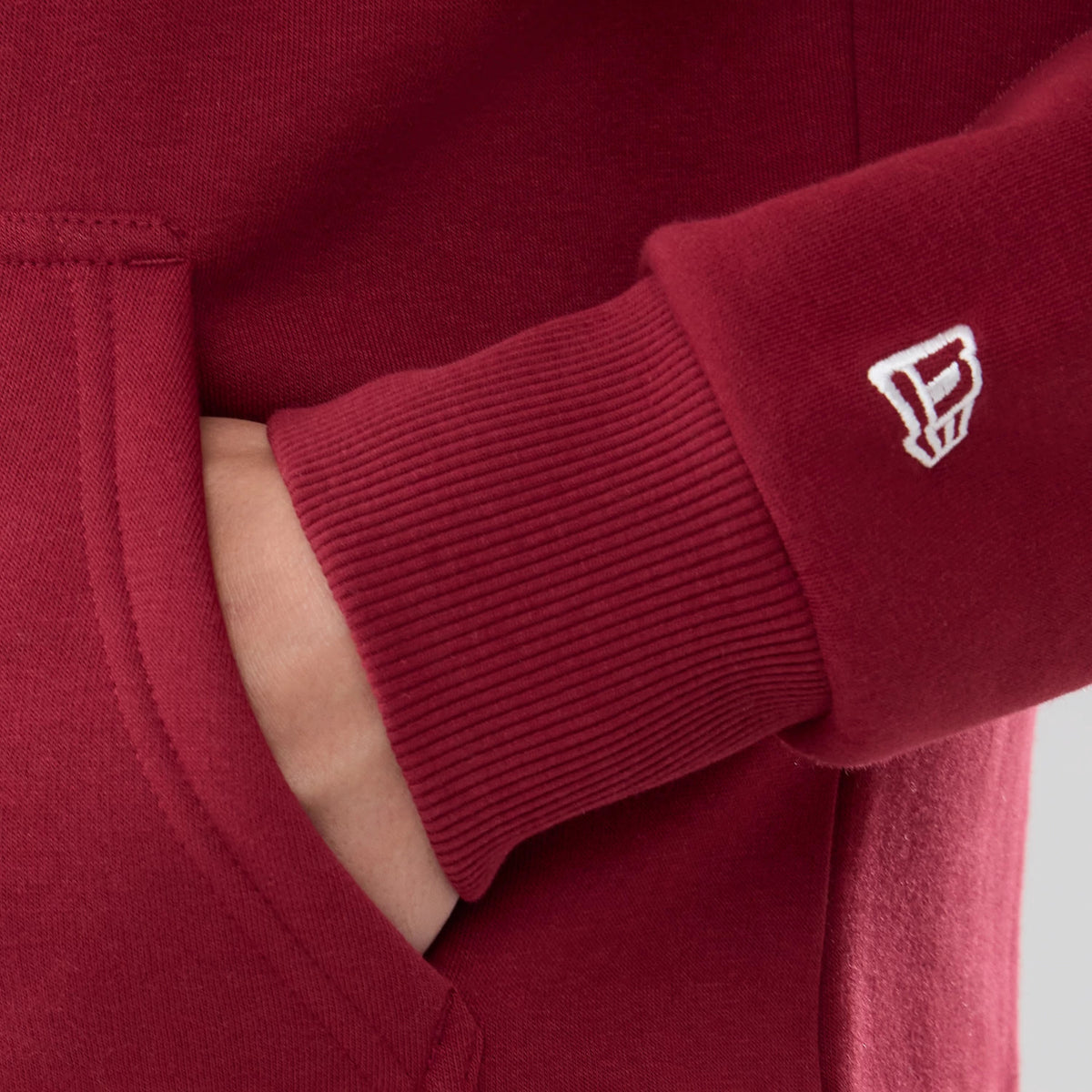 The model is wearing this NFL Patch Washington Commanders Pullover Hoodie in dark red. 6